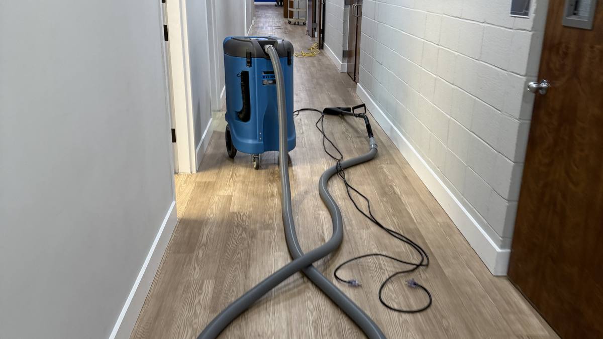 Drying equipment running in a flooded Charleston hallway